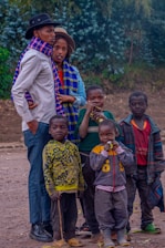 A joyful family wearing colorful scarves on a crisp autumn day outdoors.