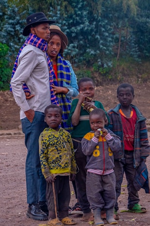 A joyful family wearing colorful scarves on a crisp autumn day outdoors.