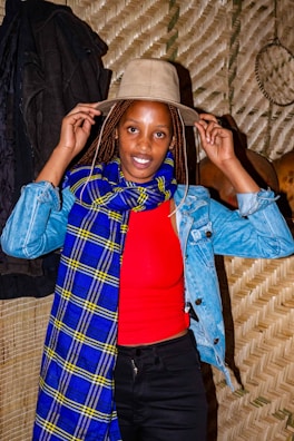 A stylish woman accessorizing her outfit with a scarf and hat in autumn.