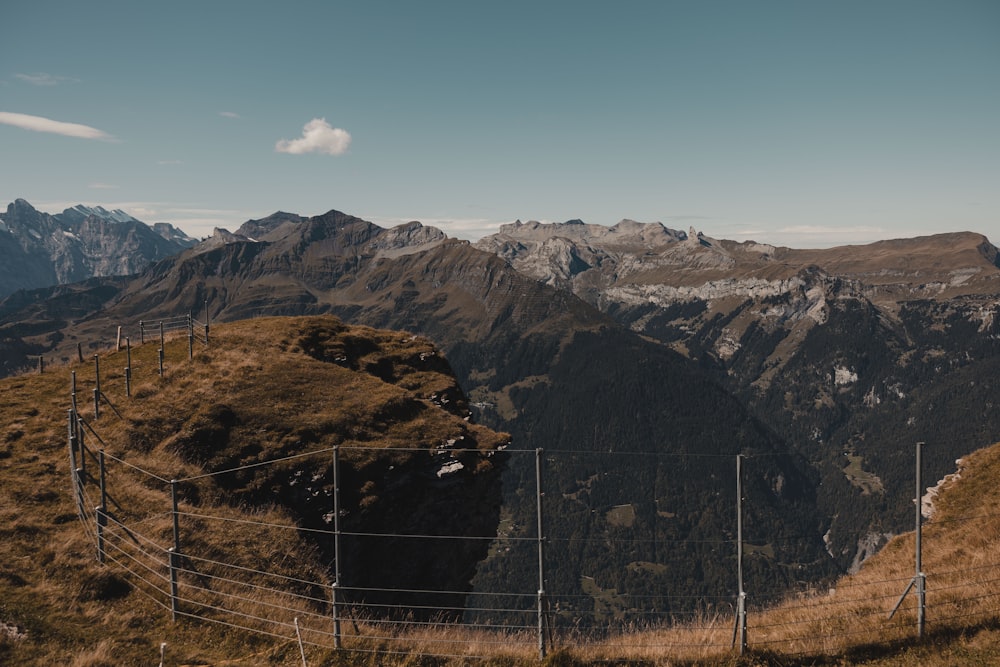 a view of a mountain range with a fence in the foreground