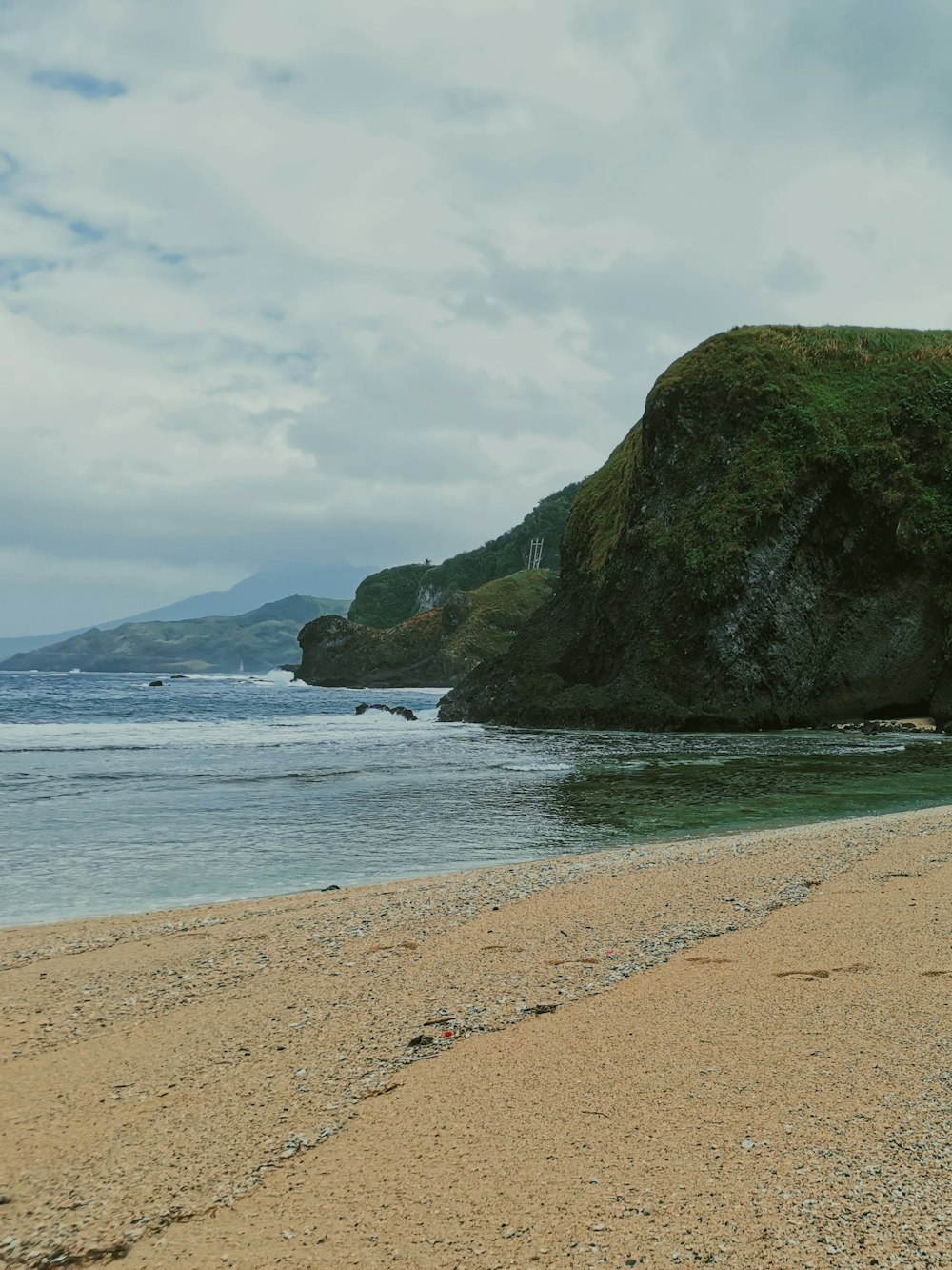 a person walking on a beach with a surfboard