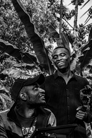 Photographer interacting warmly with a client during an outdoor photo shoot surrounded by lush greenery.