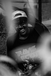 A candid shot of a customer wearing a cmdiesel hip hop artist branded cap, smiling in an urban street setting.