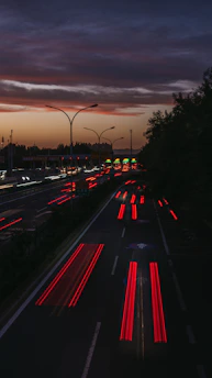 A sleek highway at dusk illuminated by streaks of fast-moving vehicle lights symbolizing swift transit.