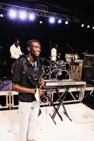 A candid shot of ppchex smiling during a rehearsal session with instruments around.