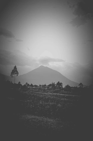 A minimalist mountain range under a pale sky, captured from a distant vantage point emphasizing vastness.
