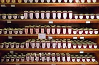 Rows of jars filled with homemade jams and preserves, labeled and ready for sale.