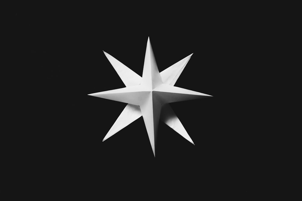 a white origami star on a black background
