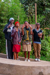 A group of diverse young men engaged in a lively mentorship session outdoors.