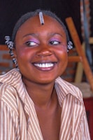 A joyful content creator sharing their story in front of a mural painted with bright pink, purple, and turquoise accents.