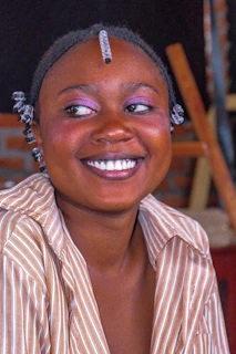 A joyful customer unboxing a Shades of Beauty order with a smile.