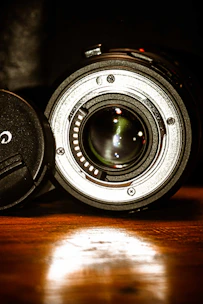 Close-up of a camera lens reflecting a stylish, dark-toned set, emphasizing detail and craftsmanship.