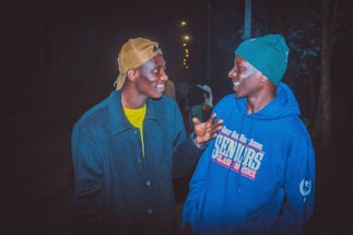 A friendly local reporter chatting with a community member outdoors.