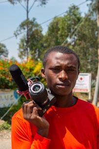 An influencer filming content outdoors with natural lighting and vibrant background.