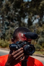 A candid shot of a journalist capturing a live event with a camera and microphone.