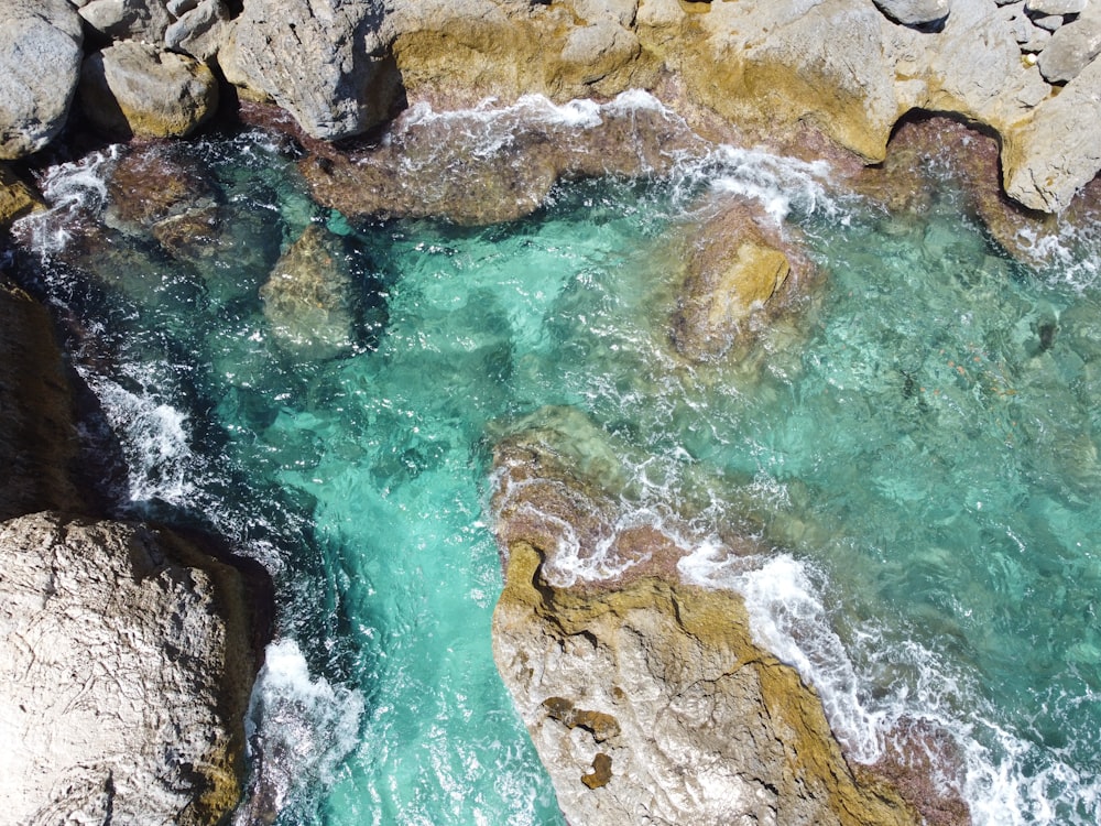 an aerial view of a body of water surrounded by rocks