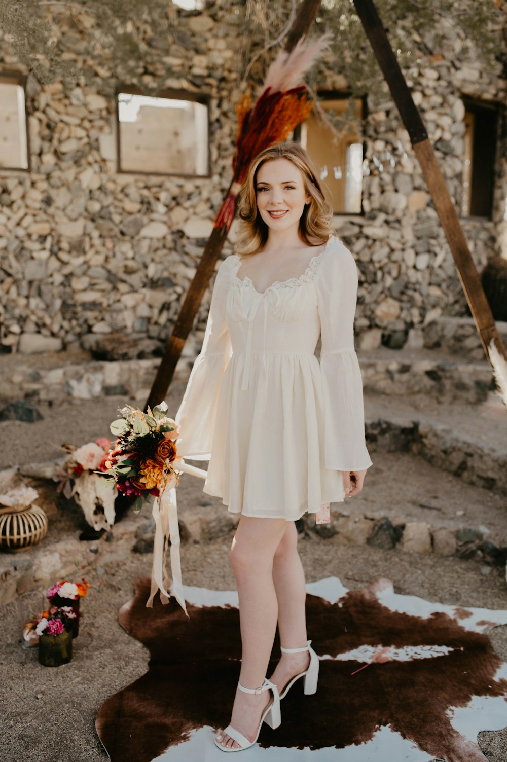 a woman in a white dress holding a bouquet of flowers