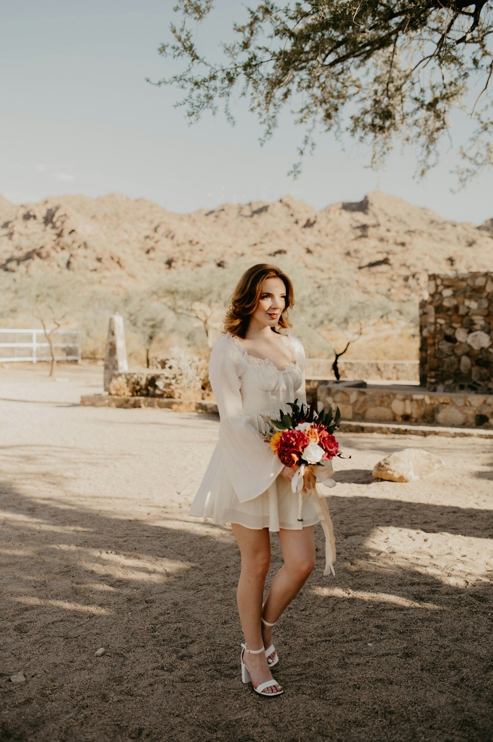 a woman in a short white dress holding a bouquet of flowers