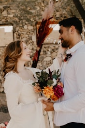 A couple sharing a joyful moment during their wedding ceremony in a scenic outdoor setting.