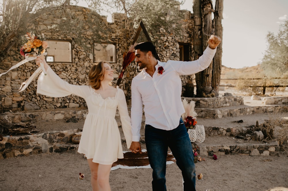 a man and a woman holding hands in front of a building