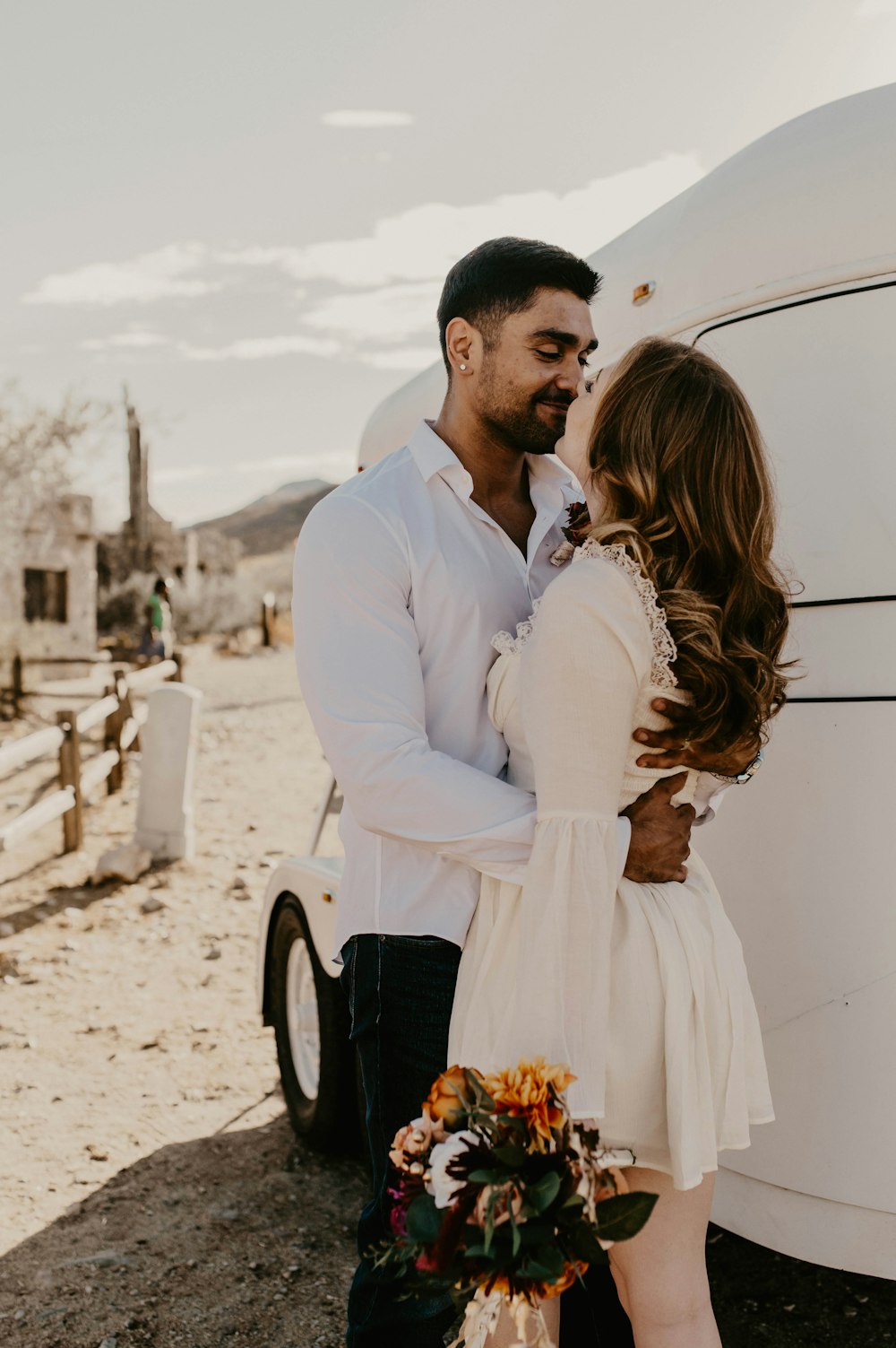a man and woman standing next to a white truck