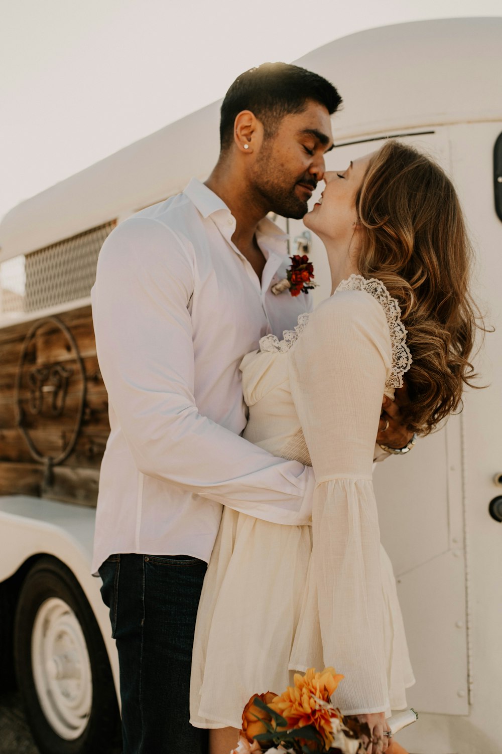 um homem e uma mulher se beijando na frente de um caminhão
