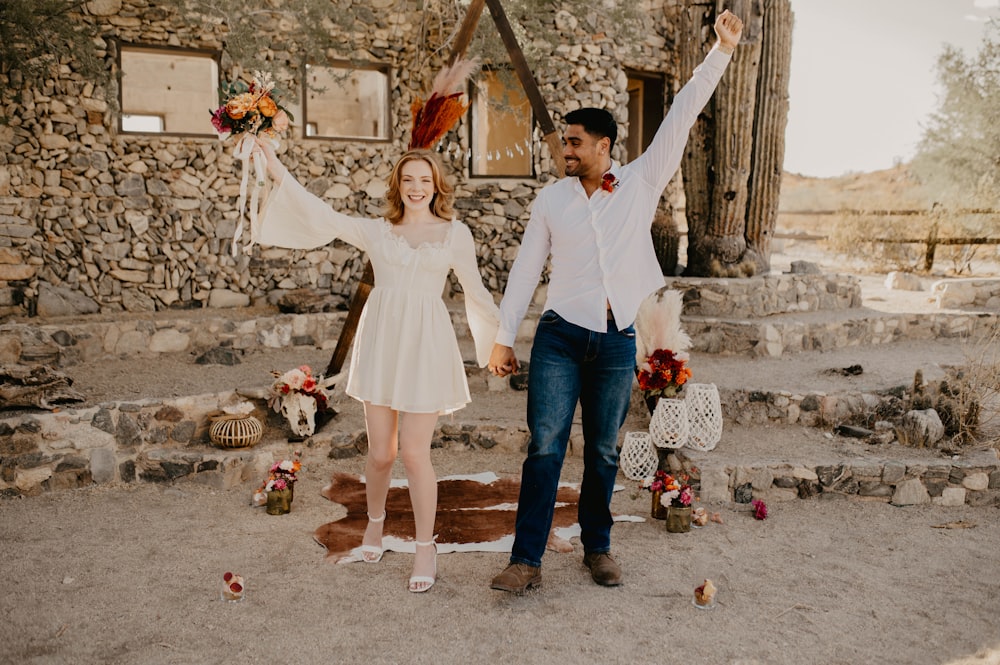 a man and a woman standing in front of a stone building