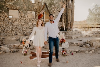 A joyful couple holding hands in a sunlit vineyard at Bodegas Fundador.