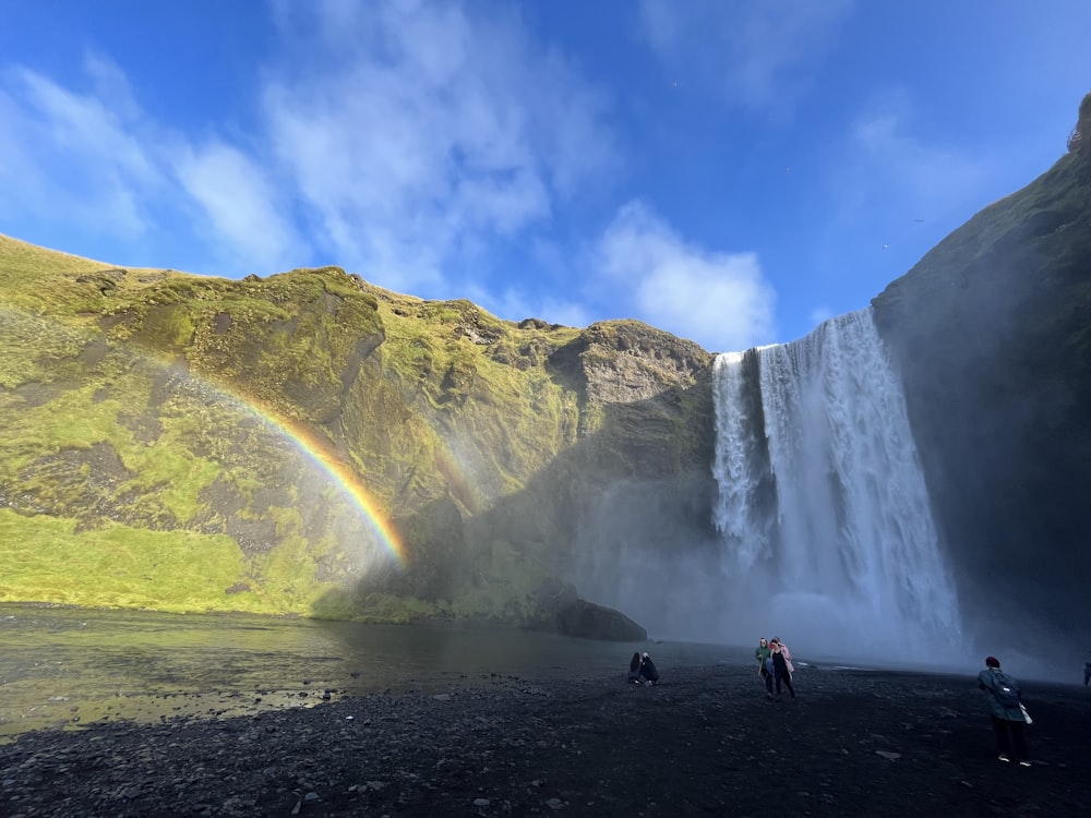 a group of people standing in front of a waterfall