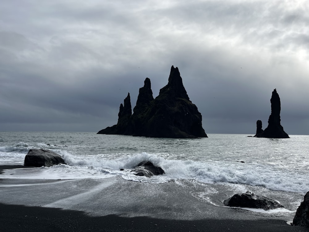 um grupo de rochas sentado no topo de uma praia ao lado do oceano