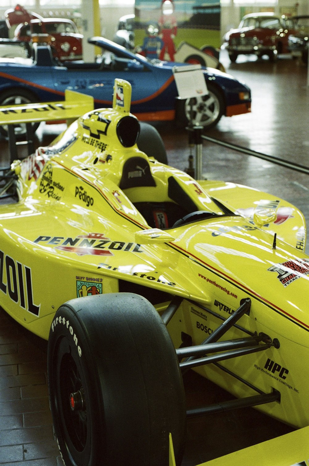 a yellow race car is on display in a museum