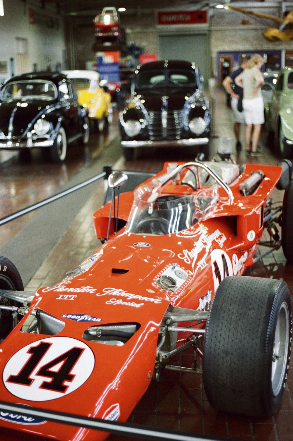 an orange race car is on display in a museum