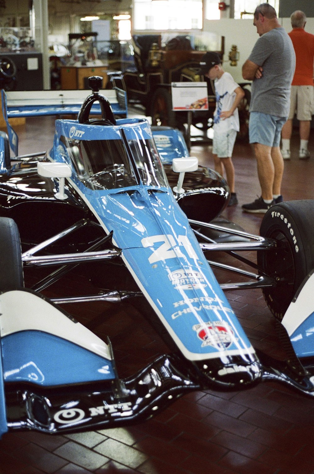 a blue race car sitting on top of a wooden floor