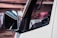 A close-up of a technician reattaching a rear view mirror in a car.