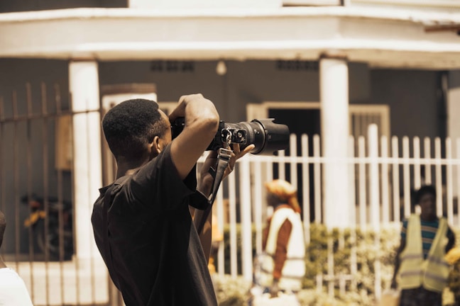 A technician photographing a commercial building's exterior for collateral documentation.