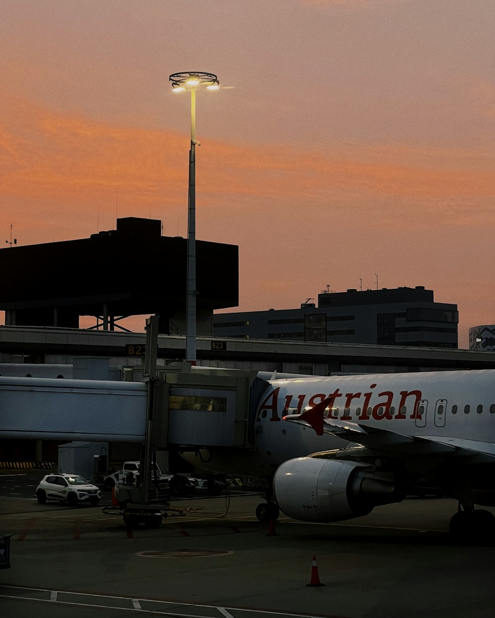 an airplane parked at an airport with a pink sky in the background