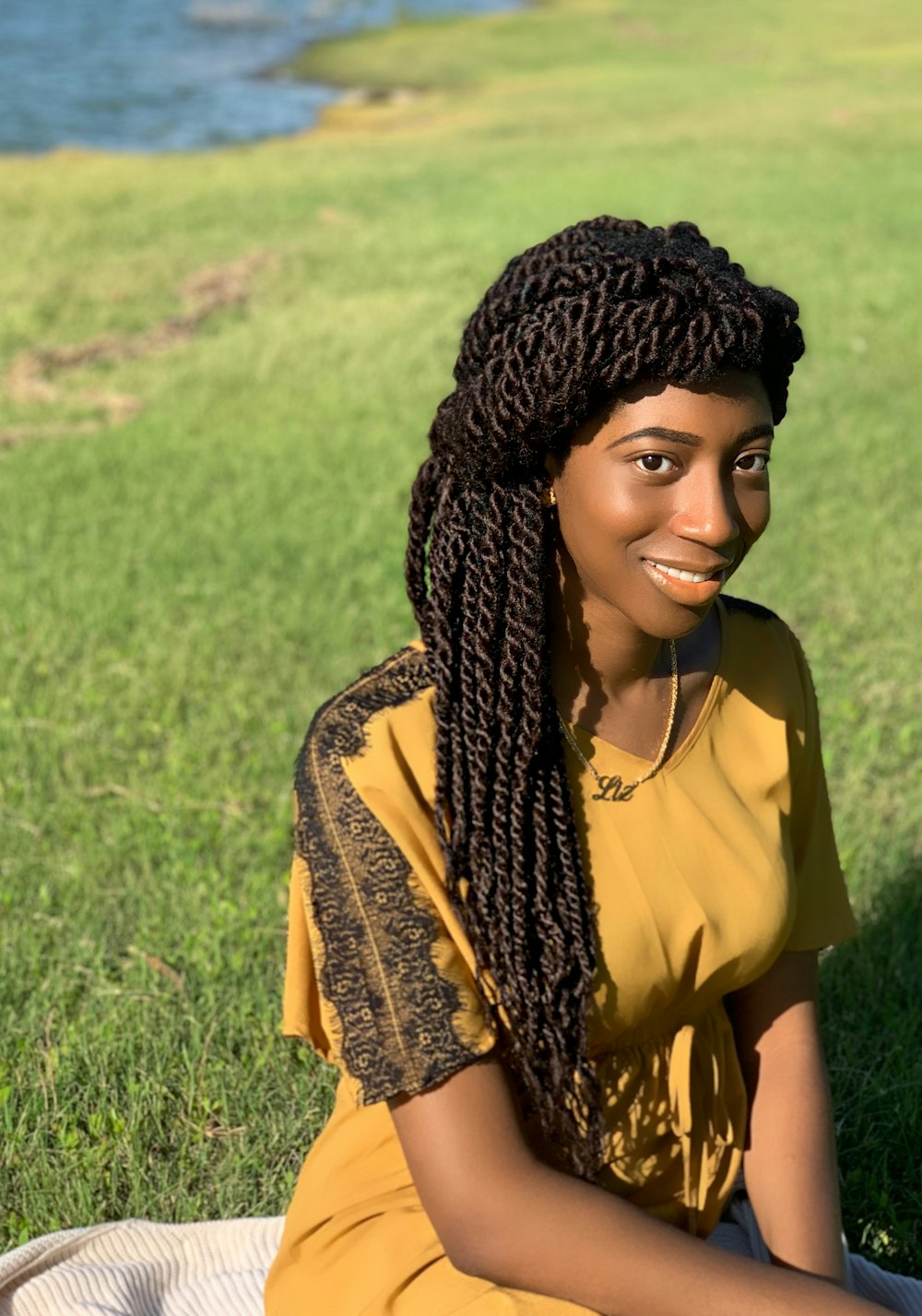 a woman sitting in the grass with a smile on her face