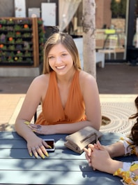 A happy person using an Android tablet outdoors, smiling while enjoying a casual app.
