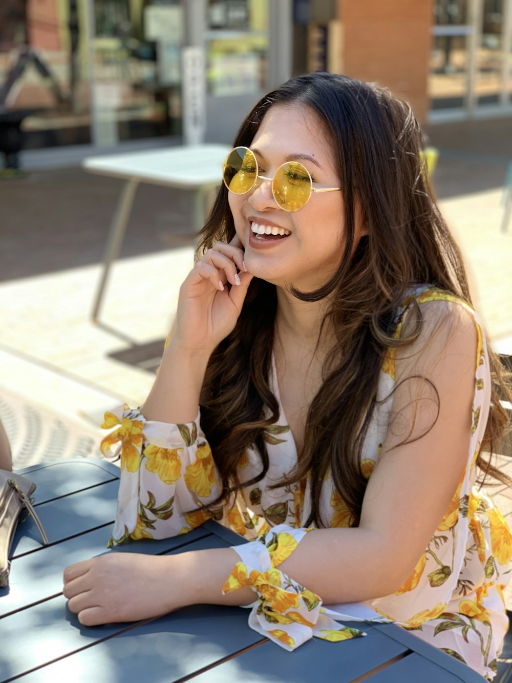 a woman sitting at a table wearing sunglasses