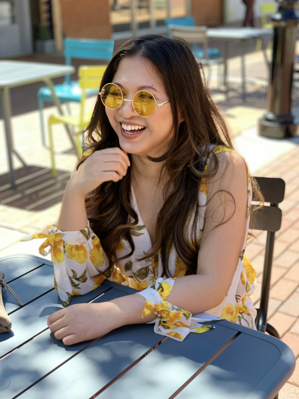 a woman sitting at a table wearing sunglasses