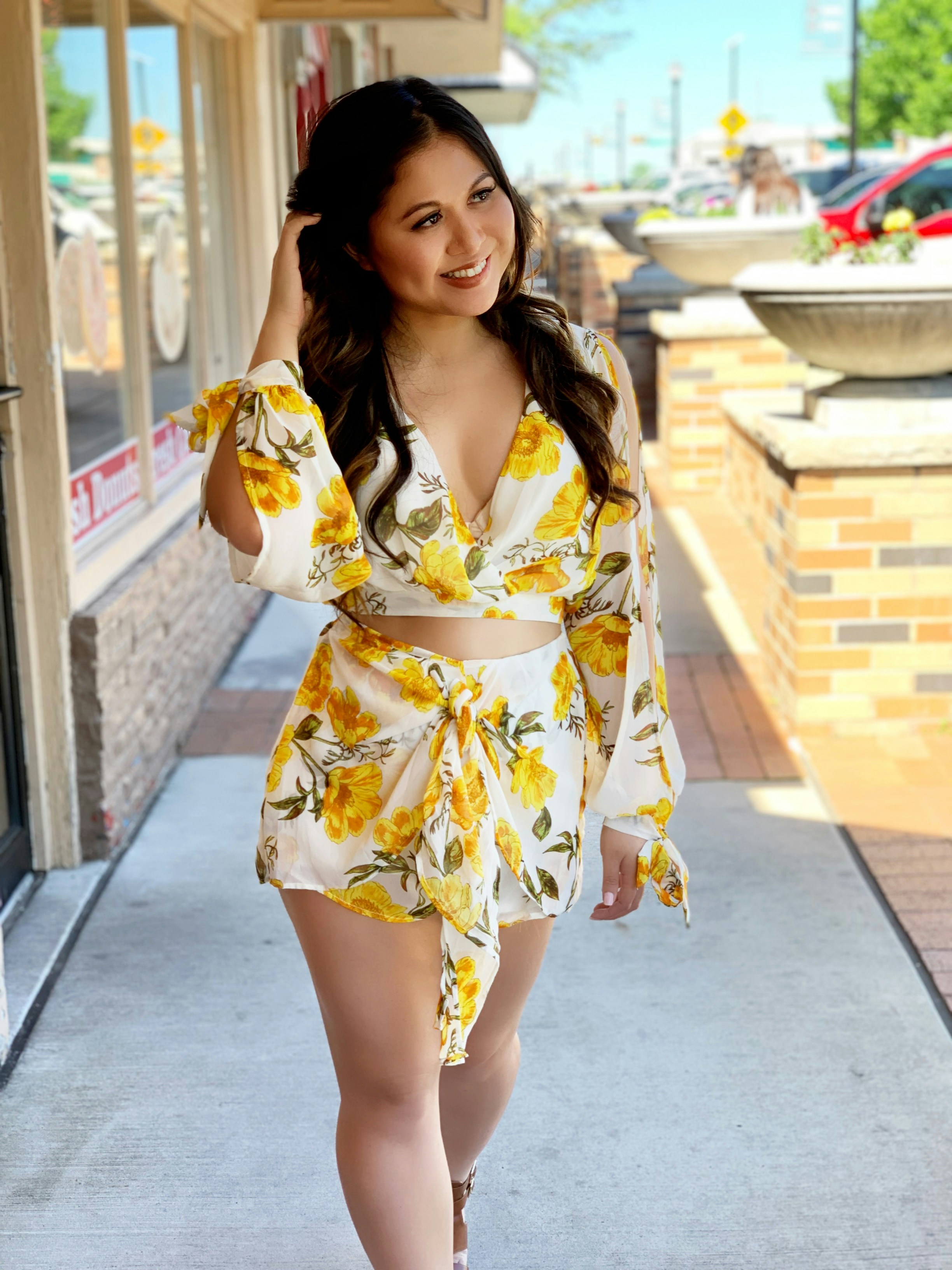 a woman is walking down the sidewalk in a yellow dress