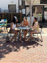 The three featured authors—Robin Ashwood, Ayla Linwood, and Kiera Collins—sharing a lively discussion outdoors under a light purple sky.