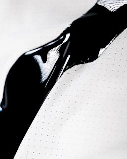 a close up of a black toothbrush on a white surface