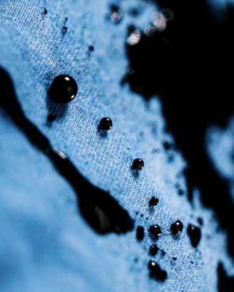 drops of water on a blue shirt with a black cat