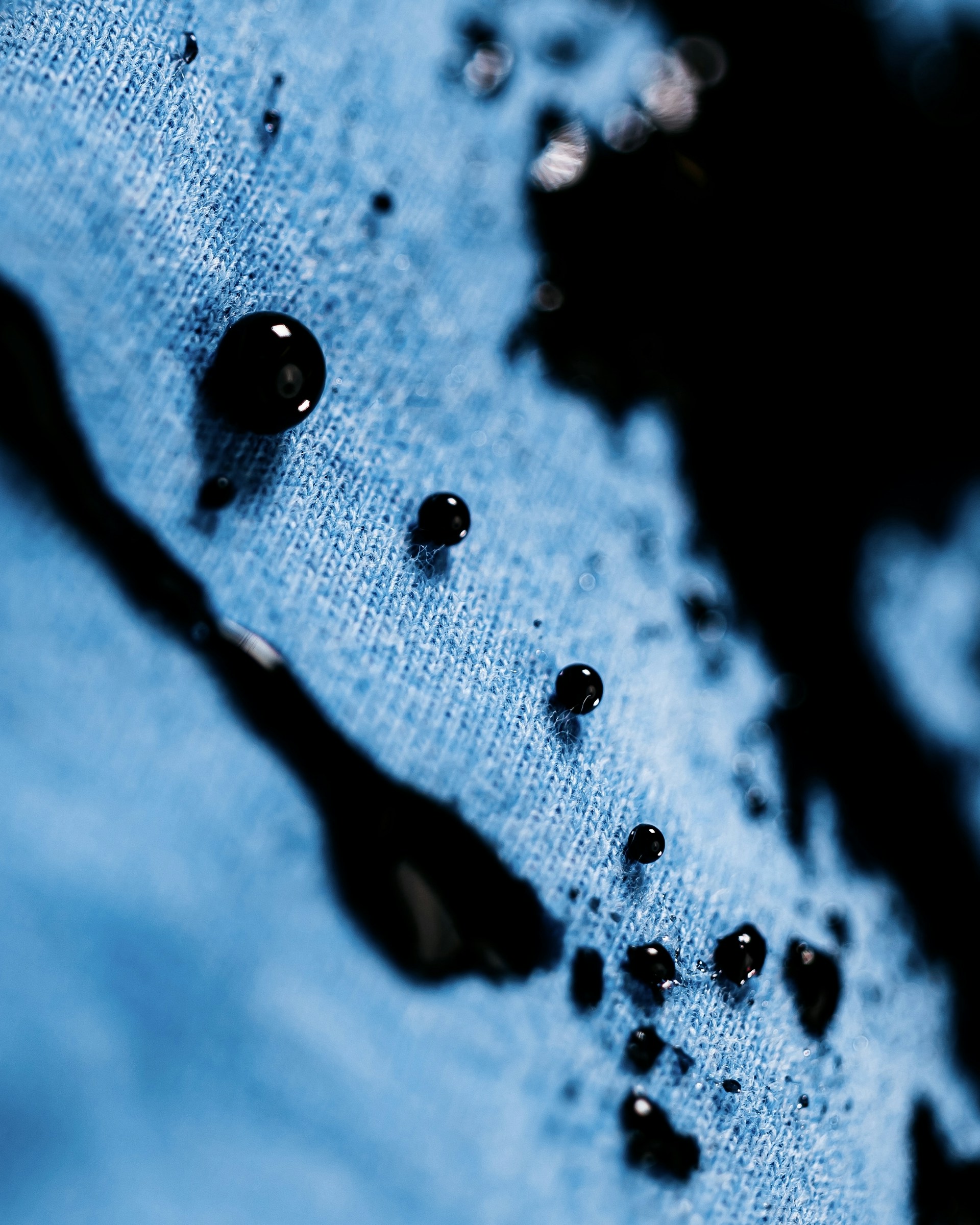 drops of water on a blue shirt with a black cat