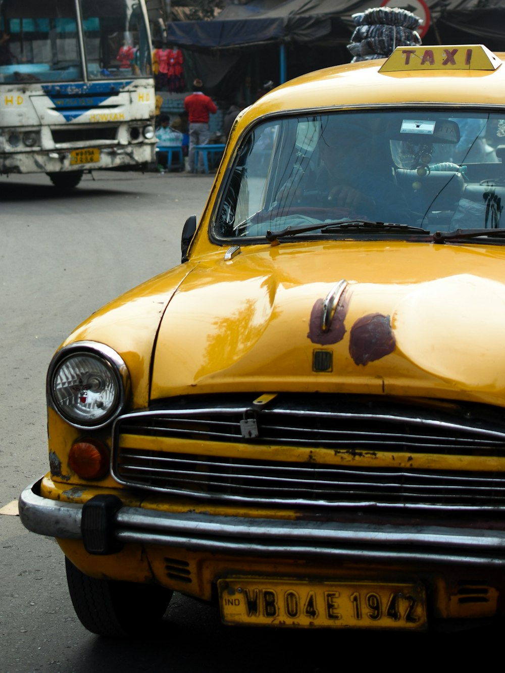 a yellow taxi cab is parked on the side of the road