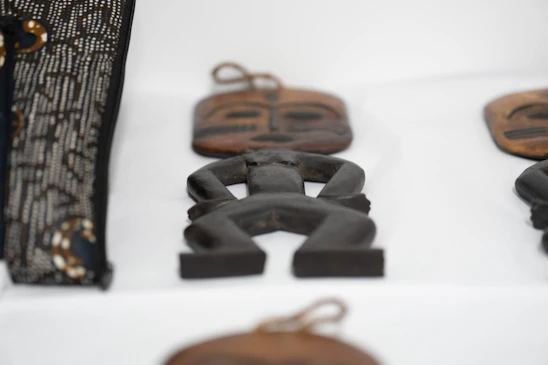 A close-up of traditional Lega wooden sculptures with intricate patterns symbolizing community values.