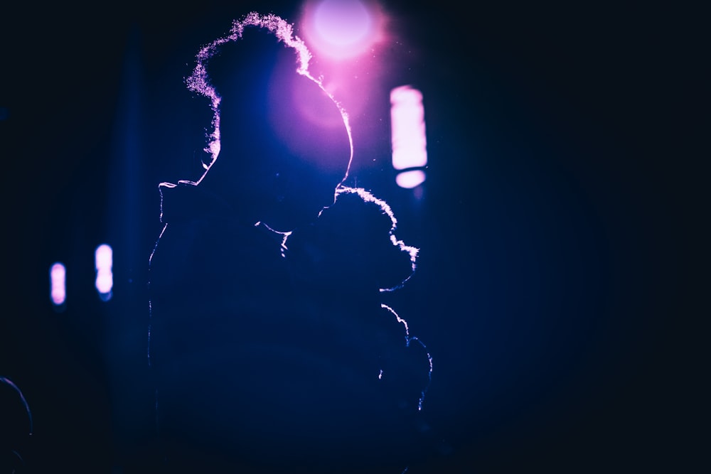 a woman holding a child in her arms in the dark