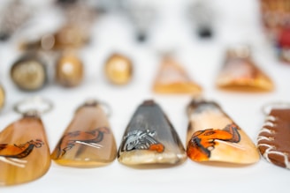 A collection of pendants and pins laid out on a rustic wooden surface.