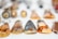 A collection of handcrafted pendants laid out on a white surface. Each pendant features intricate artwork, including animals and abstract designs, with a glossy finish. The artwork is primarily in black and orange tones, and the pendants are teardrop-shaped with varying sizes.